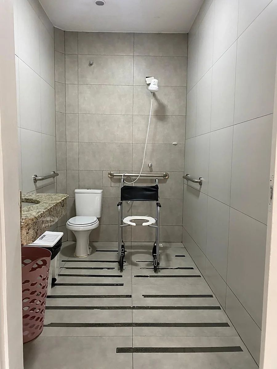 Banheiro com cadeira de banho e piso antiderrapante
