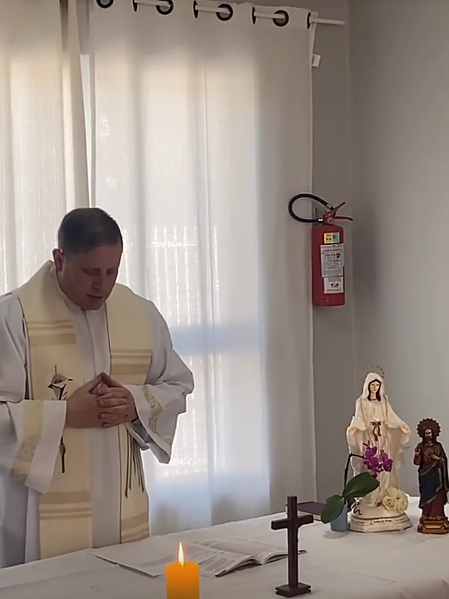 Celebração religiosa na casa, com altar montado na sala de convivência