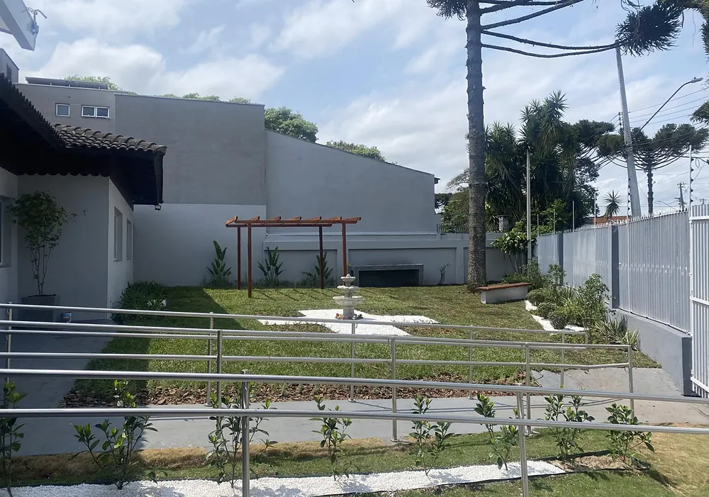 Área externa da casa, com jardim e pergolado