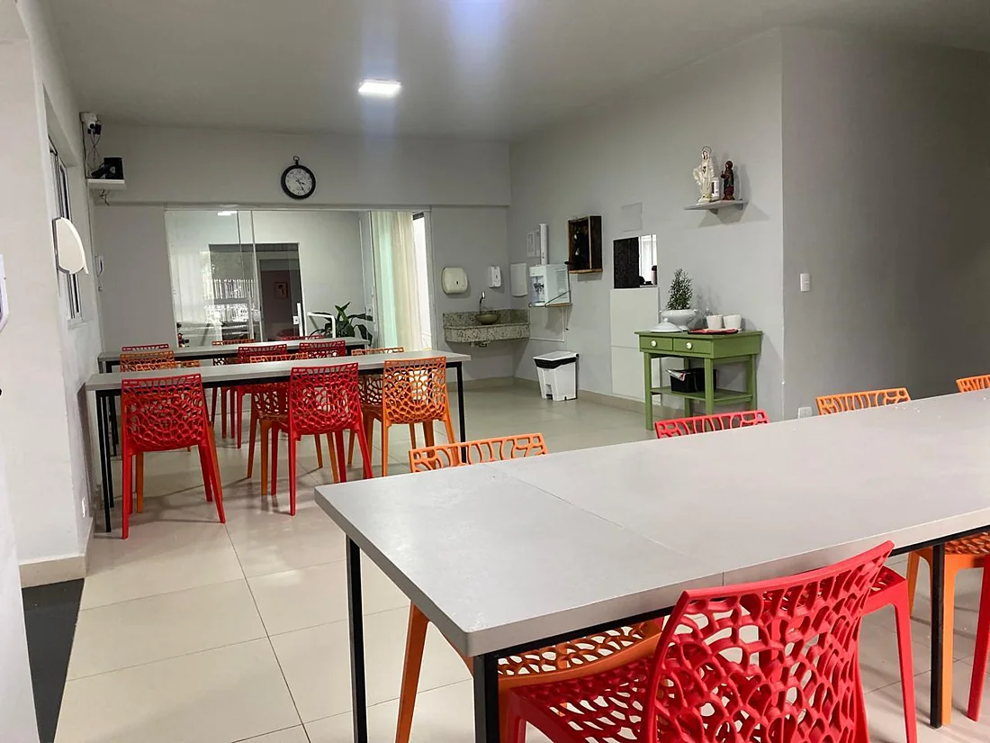 Refeitório com mesas amplas e cadeiras coloridas